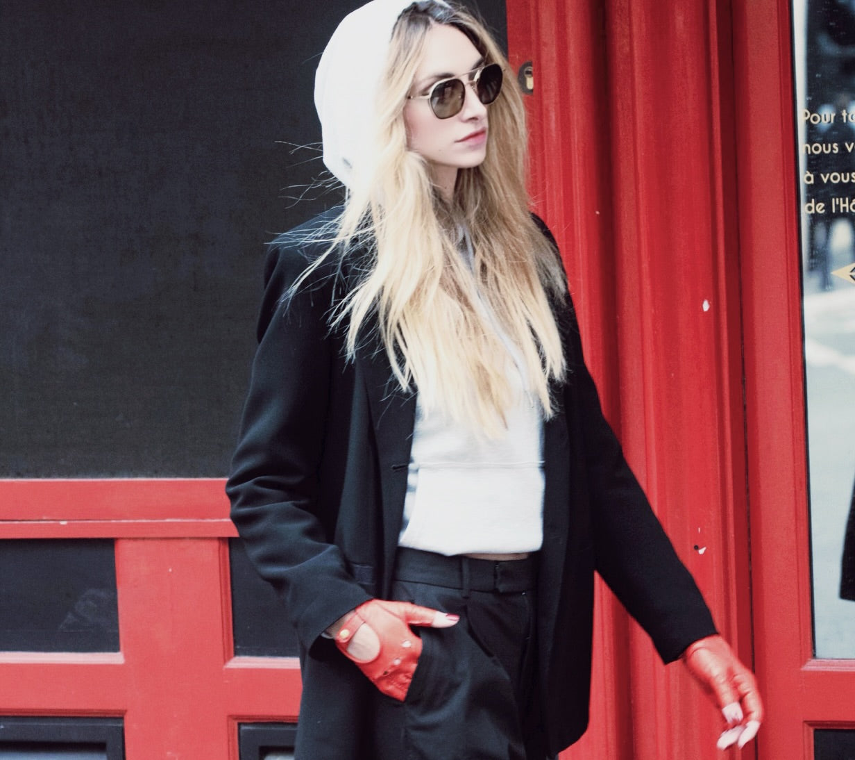A confident touché woman walking the street with red-leather-fingerless liv gloves