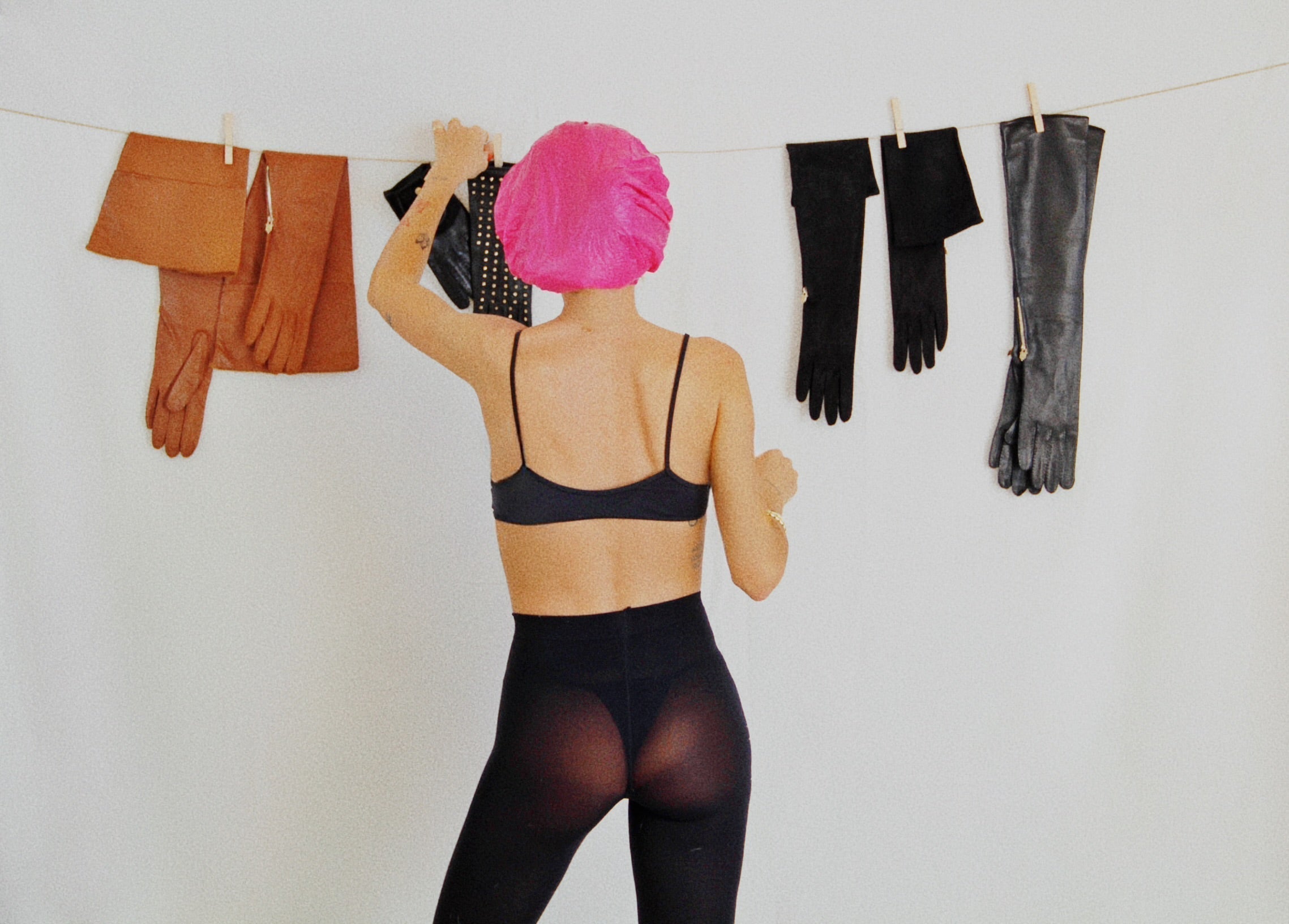 Assortment of Touché leather gloves hanging on a line in black, cognac and tan